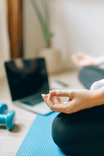 Woman practicing a calm yoga pose on a mat in a softly lit room at home.